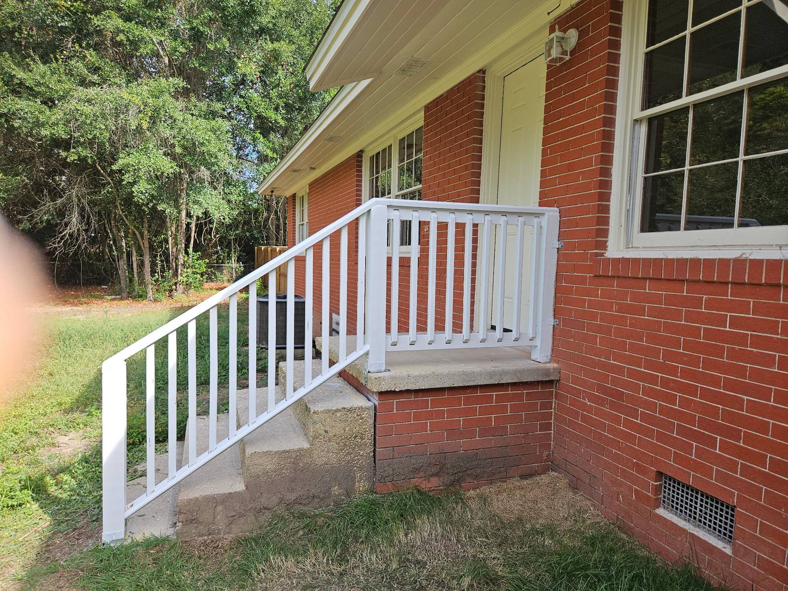Finished white porch railing on brick home