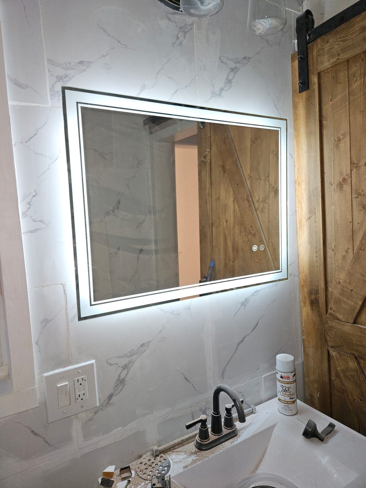 LED backlit vanity mirror installed on marble-look tile wall